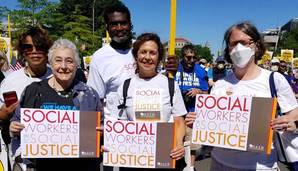 people at rally holding Social Workers for Justice posters