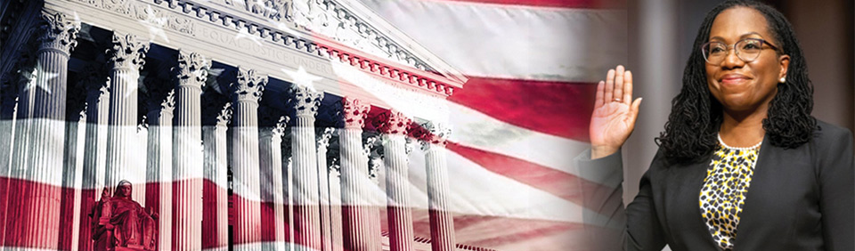 Justice Ketanji Brown Jackson with her hand raised to swear in, Supreme Court building, United States flag