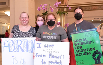 four conference attendees with abortion rights placards