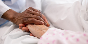 person holds a patient's hand