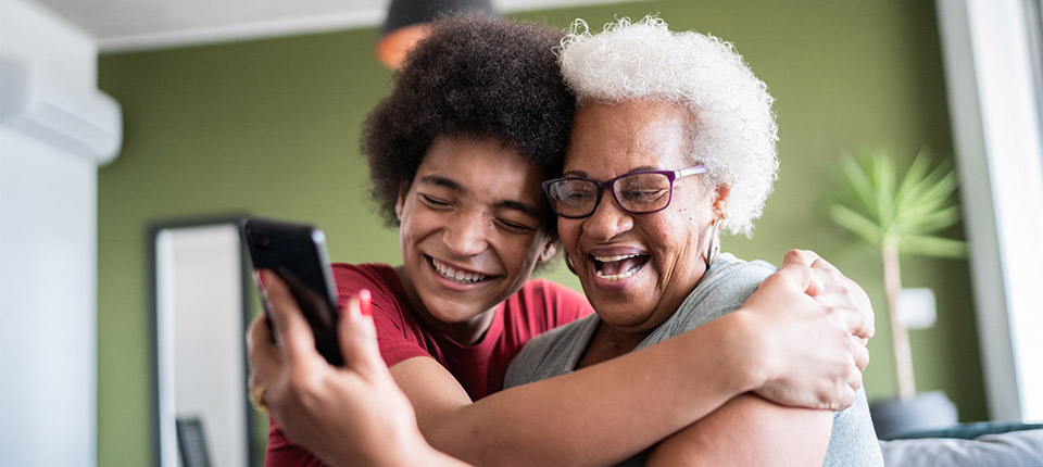 grandmother and grandson embracing while doing a video call at home