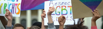 hands with Pride flag, sign that reads Respect LGBT rights