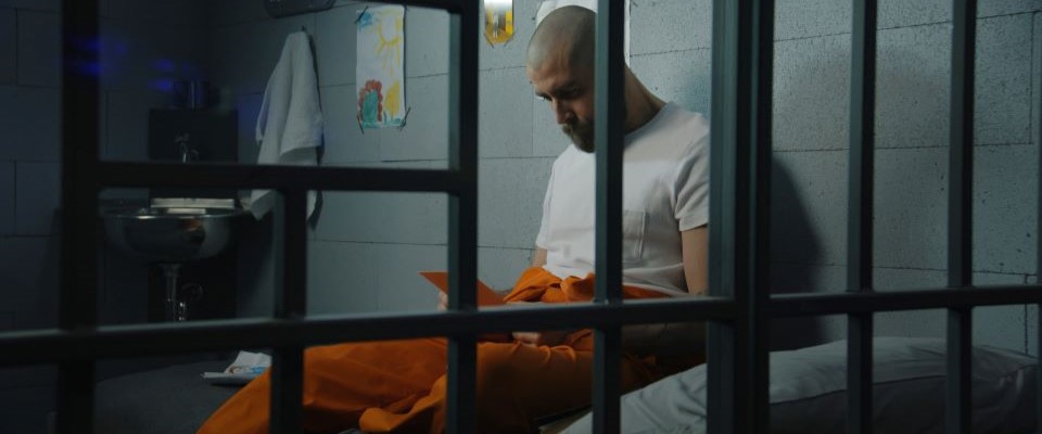 prisoner in cell reading