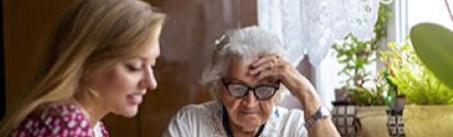 elder patient receiving help with paperwork from younger social worker