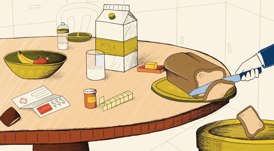 at a table full of food a hand is slicing bread into a trash can