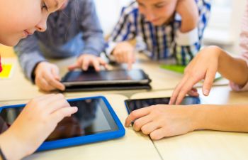children looking at computer tablets