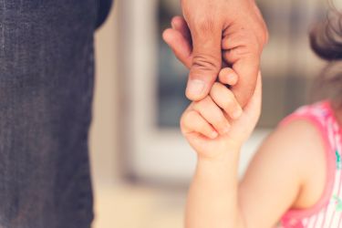 Child holding adult hand