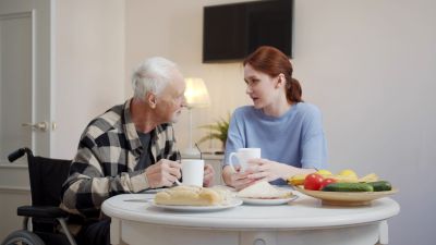 woman sitting with elderly man at table
