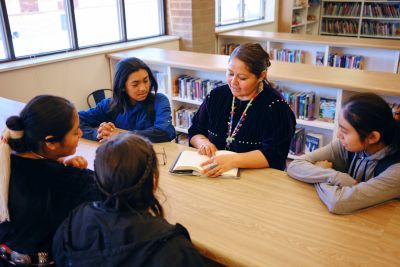 Woman teaching students in a library