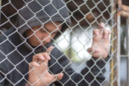 child behind a chainlink fence