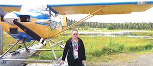woman standing next to a 2-seater airplane woman standing next to a 2-seater airplane