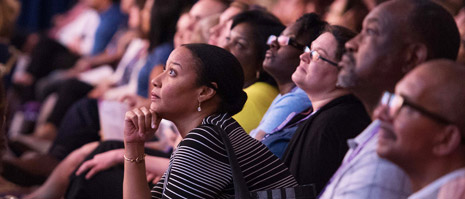 woman seated in audience looks forward