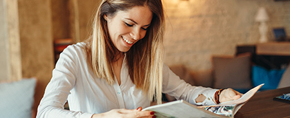 smiling woman reads a magazine