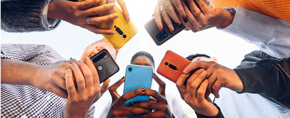 group of people using mobile phones with colorful covers