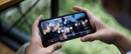 hands holding phone while watching videos
