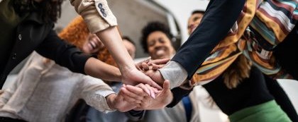 group smiling with hands put together