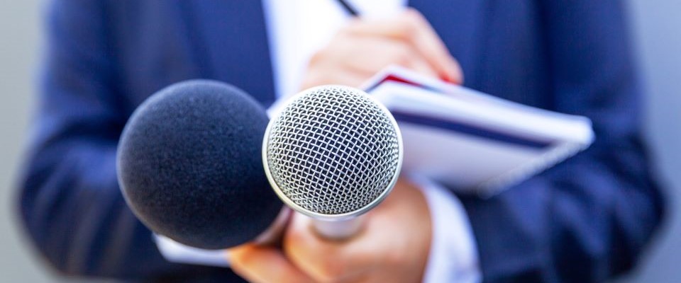 hand holding microphones and notebook