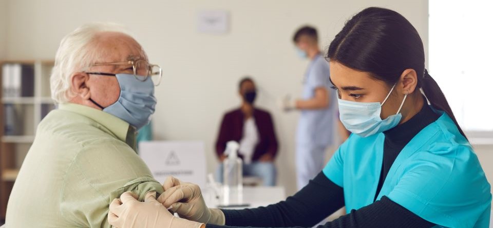 nurse preparing older man for an injection