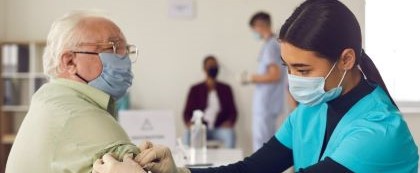 nurse preparing older man for vaccine