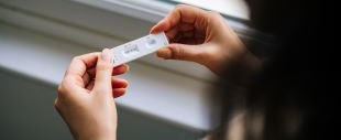 person holding COVID test kit