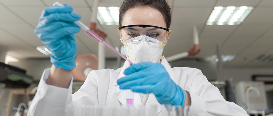 scientist in protective gear working in a lab