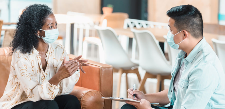 woman meeting with social worker who is holding a clipboard