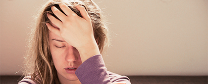 stressed out woman with hand on her forehead