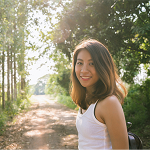 smiling woman in a sunny forest clearing