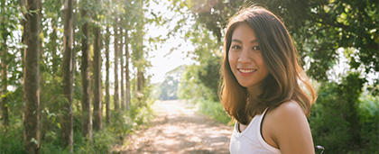 smiling woman in a sunny forest clearing