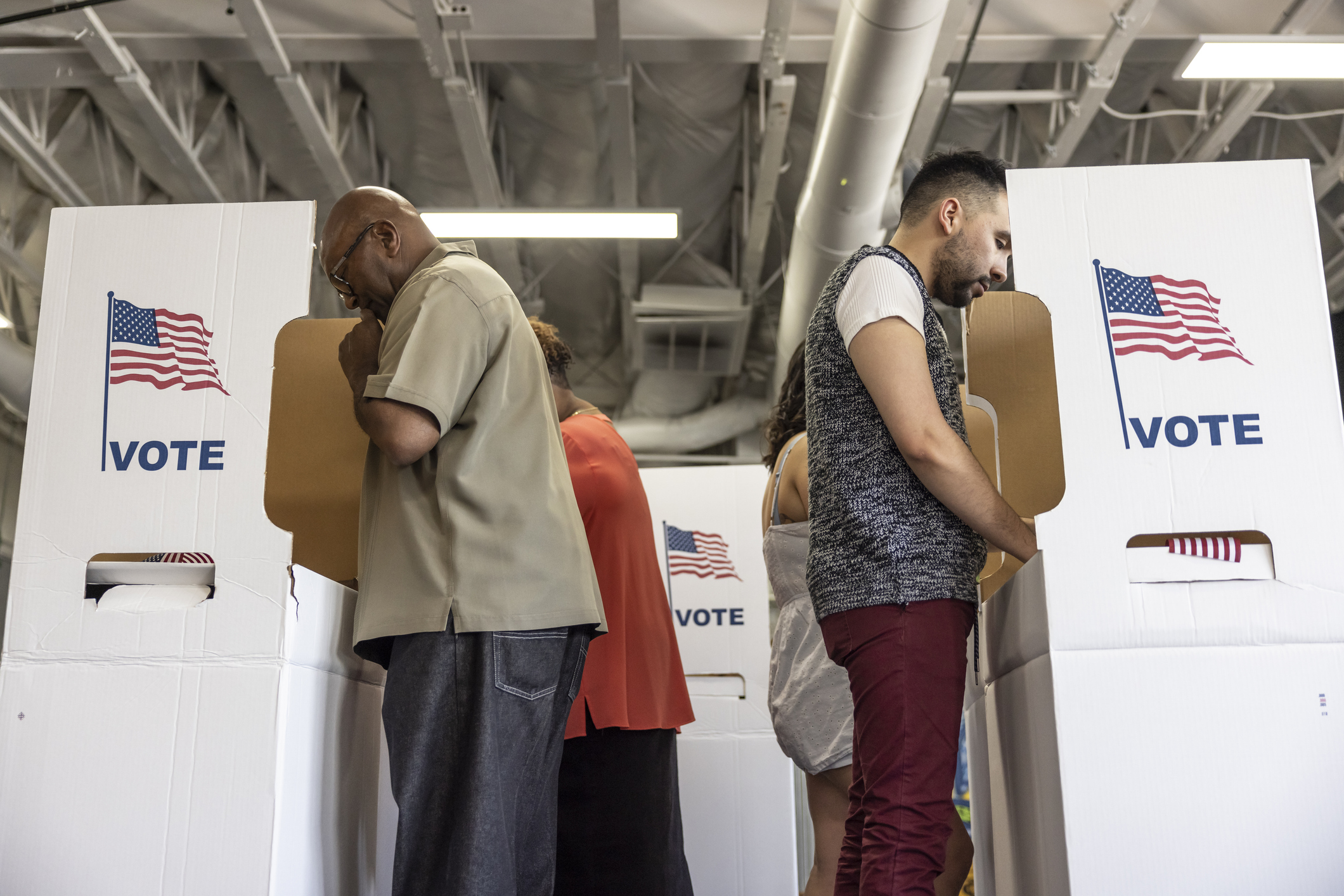 people standing at voting booths