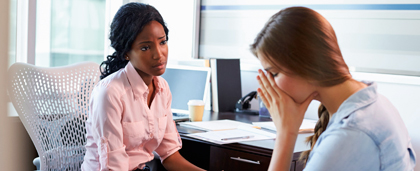 woman at desk empathizes with crying woman in chair