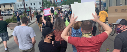 group of protesters marching with signs in Fairbanks, Alaska
