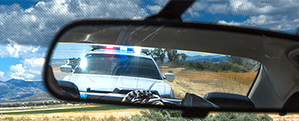 police car seen in rearview mirror
