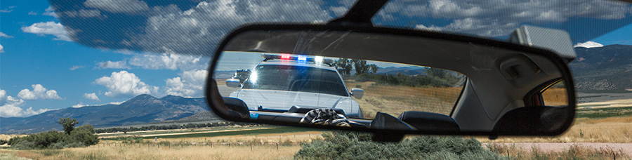 driver's view of police car in rear view mirror